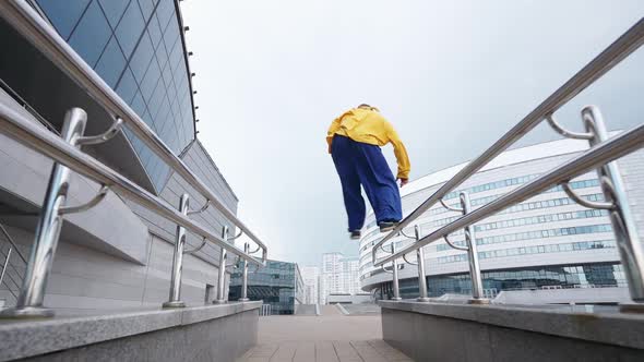 Free Running Young Man Runs Over Obstacles in the City and Doing a Flips on Training Area Near