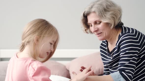Grandmother Spending Time with Her Granddaughter in the Bedroom