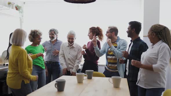 Happy multiracial people with different ages and ethnicities having fun dancing at home