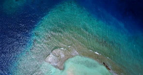 Wide flying abstract view of a white sandy paradise beach and aqua turquoise water background in col