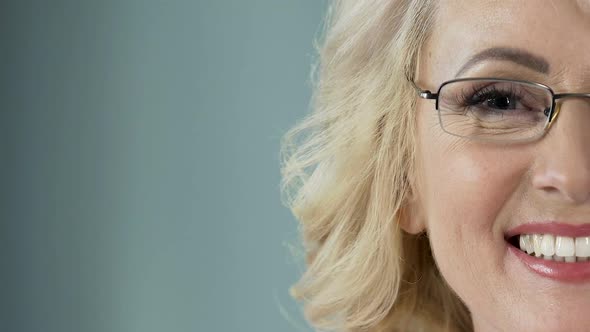 Beautiful senior blonde with eyeglasses smiling into camera, health care