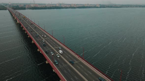 Aerial Top View Of Vehicles On Bridge Over River At Cloudy Day Drone Flying Forward Over Cars Dnipro