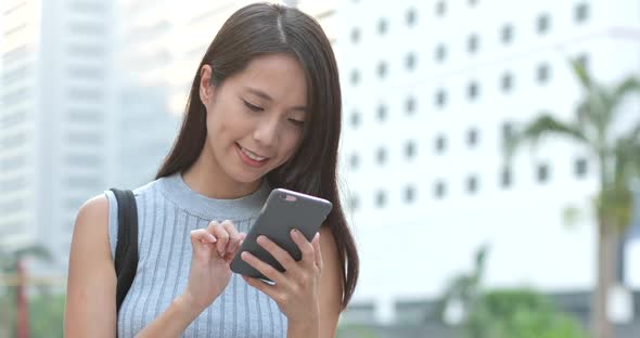 Woman using mobile phone in city 