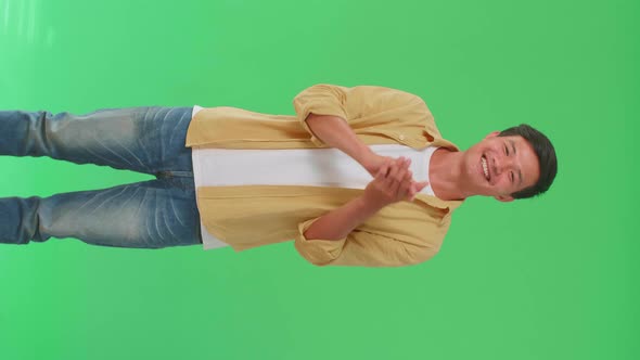 Young Asian Man Clapping Her Hands In The Green Screen Studio