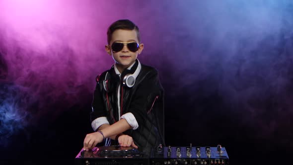 Stylish Boy Dj with Glasses Playing on Vinyl. Smoky Background