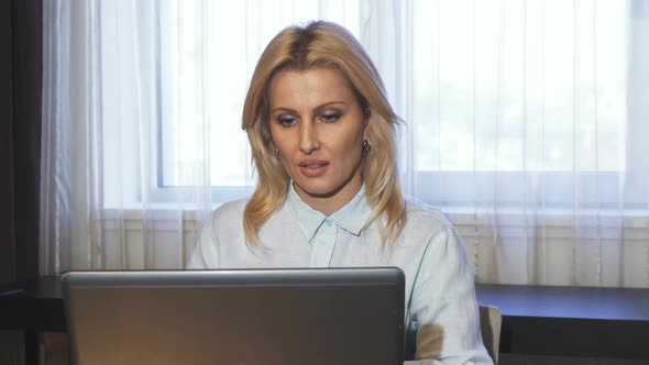 Business Lady Drinks Coffee While Sitting at Her Laptop