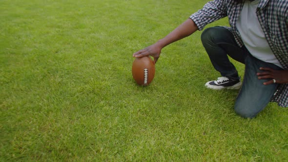 Black Father Teaching School Age Son to Play American Football