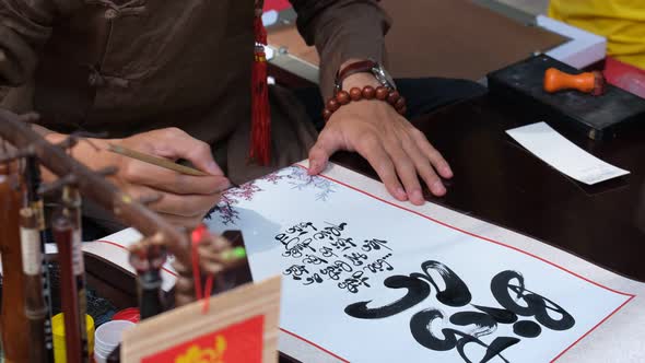 Vietnamese scholar writing calligraphy at lunar new year