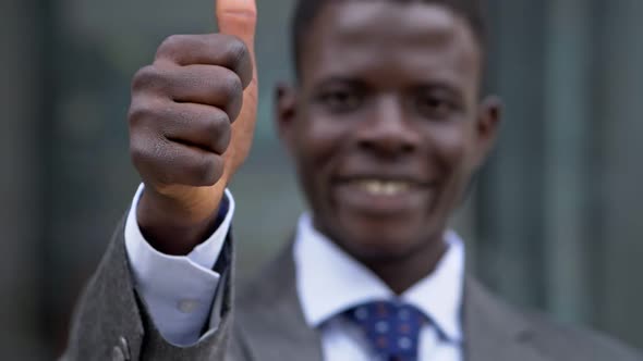 Blurred smiling young black business man making thumb up -slow motion