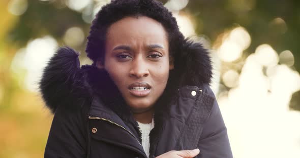 Portrait of Frozen African American Young Woman Wears Warm Jacket Stands Alone Isolated Outdoors