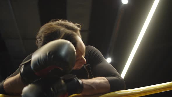 Tired Boxer Making Break After Fight at Gym. Fit Man Having Rest in Sport Club