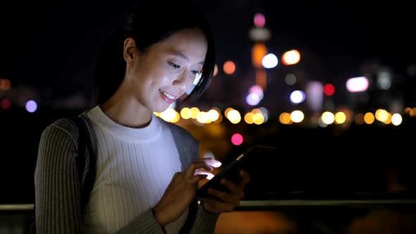 Woman watching on cellphone at night 