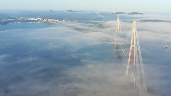 The Pylons of the Giant Cablestayed Bridge Rise Above the Seaside Morning Fog