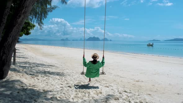 Couple Men and Woman on the Beach in Thailand with Swing on the Beach of Naka Island Phuket Thailand