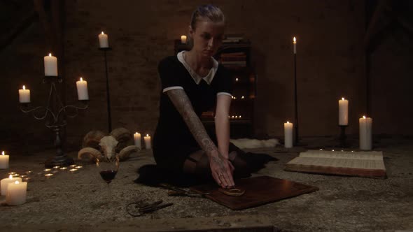 Frightened Woman Using Ouija Board In Candle Lit Attic