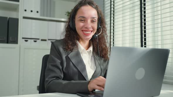 Portrait of Latino beautiful business woman call center smile while work in office look at camera.