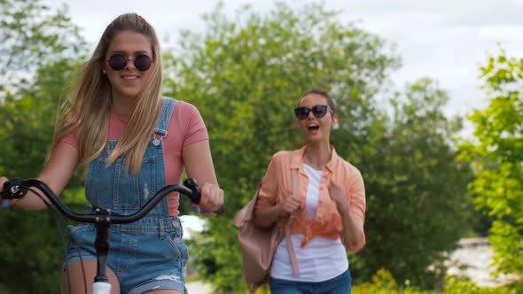 Teenage Girls or Friends with Bicycle in Summer