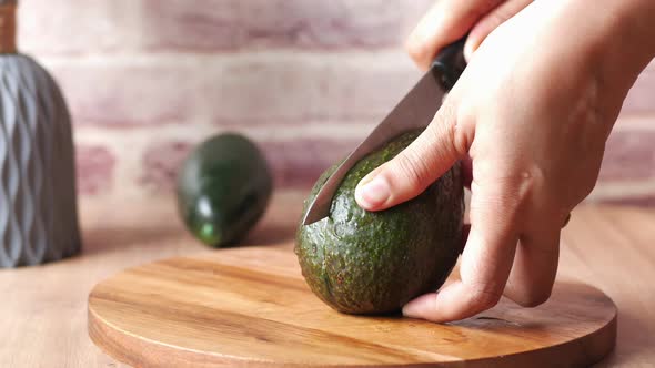 Women Hand Cutting Slice of Avocado with Knife