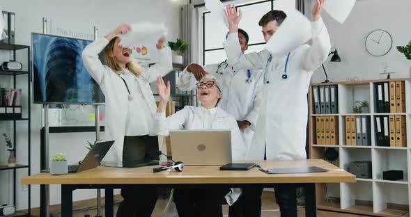 Doctors Recieving Good News on Laptop Screen and Giving High Five