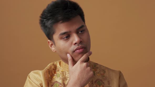 Meditative Indian man in national cloth having idea