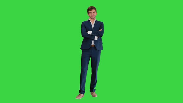 Handsome Young Businessman Standing Arms Crossed, Smiling Confidently on a Green Screen, Chroma Key.