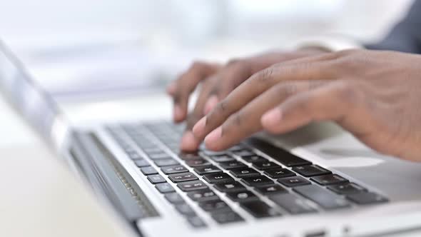 Close Up of Fingers of African Man Typing on Laptop Keyboard 