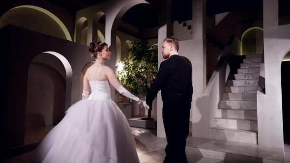 Elegant Couple is Dancing Waltz in Romantic Dark Ballroom in Royal Palace