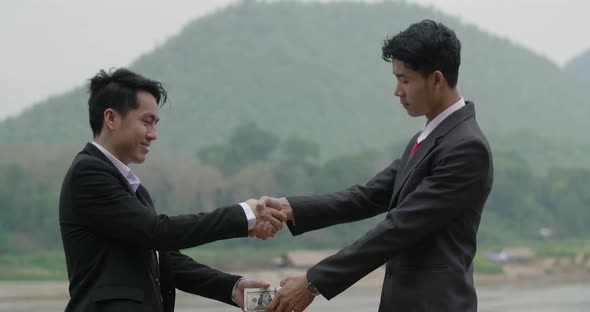 Asian Businessman Handshake and Giving Money