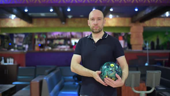 Bowling player looking in front of him while holding a ball to play