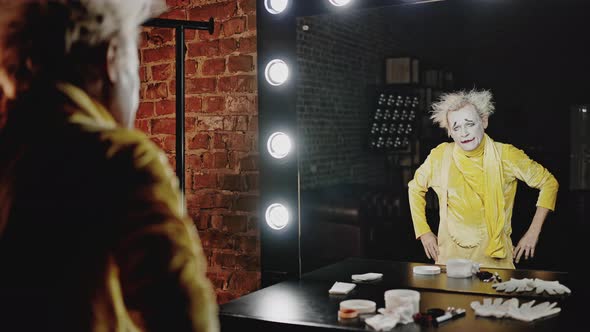 Angry Mime Looks at Reflection in Mirror in Dressing Room