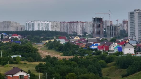 Flight Over Private Houses Against the Backdrop of Highrise Buildings