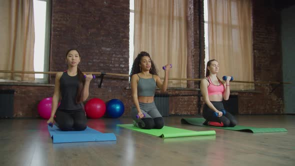 Multiracial Fit Women Doing Weight Training at Gym