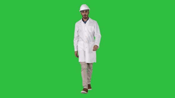 Arab engineer in helmet and white robe walking forward