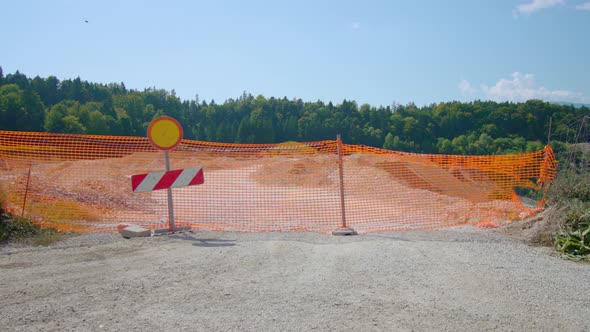 Huge Sandpit Surrounded By Bright Mesh Fence with Stop Sign