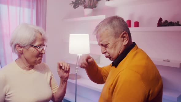 Happy Elderly Couple Dancing at Home with Disco Lights