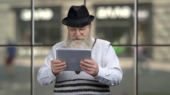 Funny Retired Man Using Computer Tablet
