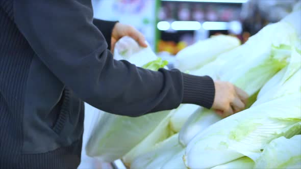 Man Buys Food, Picks Carrots, Cabbage, Lettuce, Cauliflower in the Market, in the Supermarket