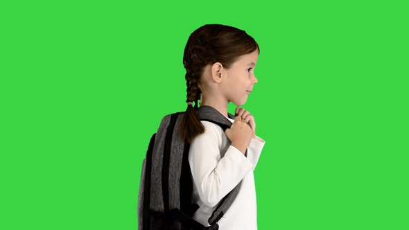 Smiling Little Girl Walking To School with a Backpack on a Green Screen Chroma Key