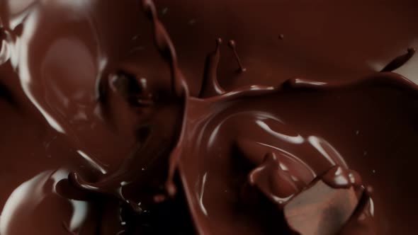 Super Slow Motion Shot of Raw Chocolate Chunks Falling Into Melted Chocolate at 1000Fps.