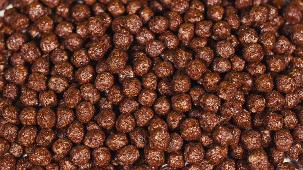 Closeup Pan of Chocolate Cereal Balls in White Bowl for Breakfast on Wooden Table