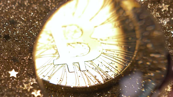 Macro View Through Loupe in Man Hand on Bitcoin Model