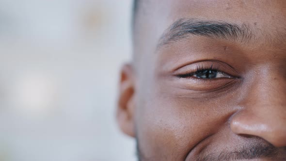 Closeup One Black Male Eye Looks at Camera with Happy Gaze