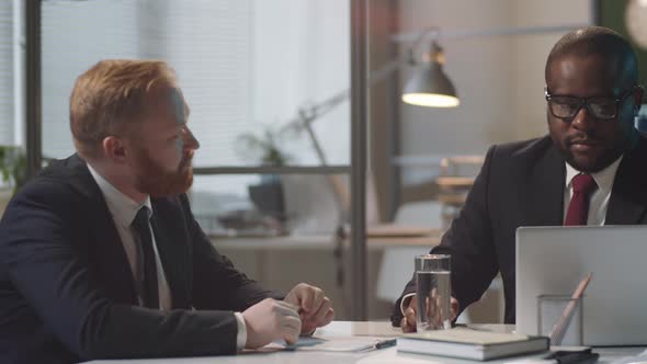 Two Multiethnic Businessmen Talking in Office