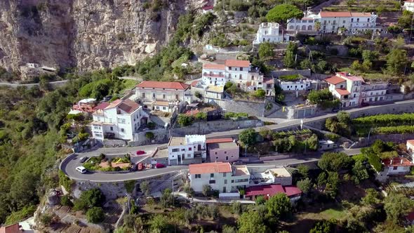 Italian Amalfi coastline winding road turning with terraces near Positano, Aerial circling shot