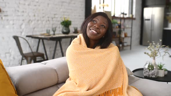 Young Multiracial Woman Covered in a Cozy Yellow Soft Blanket Staying at Home