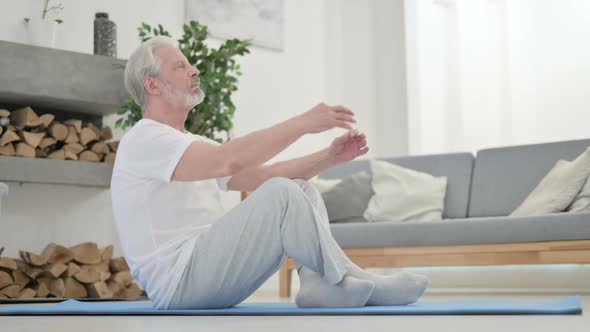 Old Man Meditating on Yoga Mat at Home