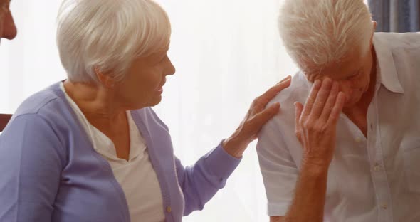 Group of senior friends consoling a senior man