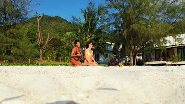 Ladies together enjoying life on luxury island beach time by turquoise water and white sand backgrou