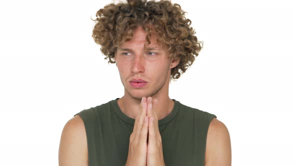 Portrait of Nervous Man with Curly Hair in Green Muscle Shirt Holding Hands Like Praying Thinking