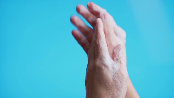 Hands Washing Her Hands Using Soap Foam on Blue Background, Close Up Shot. Prevention From Covid19